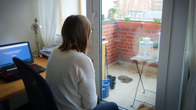 Frau schaut aus dem Fenster